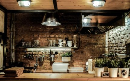 Eine charmante rustikale Küche mit freiliegenden Holzbalken, Vintage-Dekor und einer Spüle im Bauernstil.